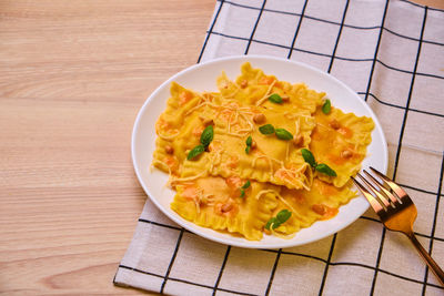 Homemade pumpkin ravioli with ricotta cheese served basil