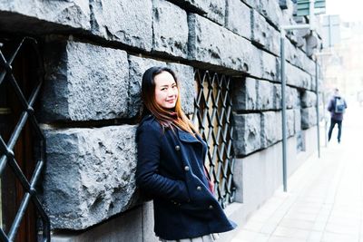 Portrait of woman against wall