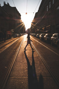 Man walking on railroad tracks in city