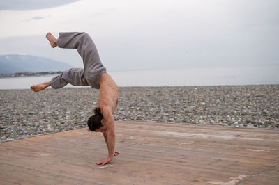 Man doing handstand at beach