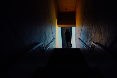 Low angle view of silhouette woman standing on steps