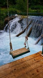 Swing over water in forest