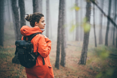 Woman walking in the foggy autumn forest.