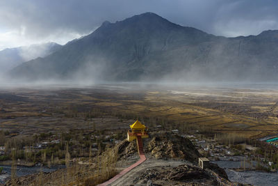 Aerial view of temple building against mountain during foggy weather