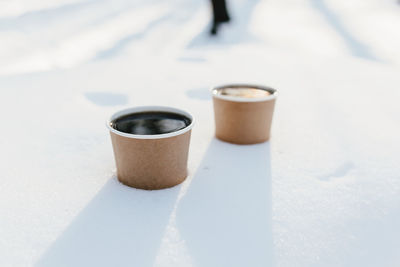 Two cups of coffee in the snow in the forest. high quality photo