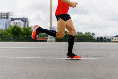 Low section of man running on road