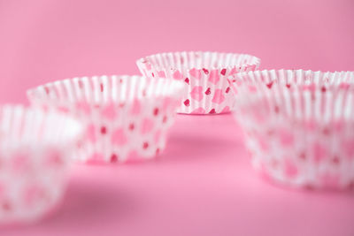 Close-up of cupcakes on table against pink background