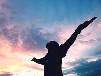 Low angle view of silhouette statue against cloudy sky