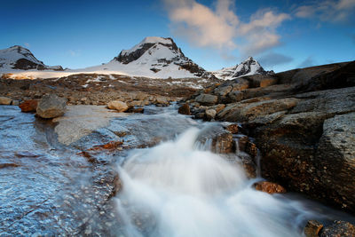 Scenic view of river by mountains against sky at gran paradiso national park