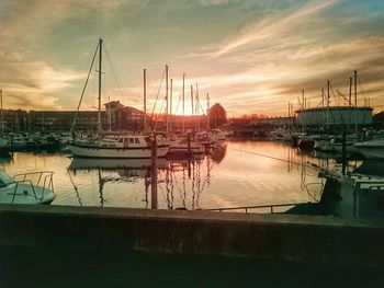 Boats in harbor at sunset