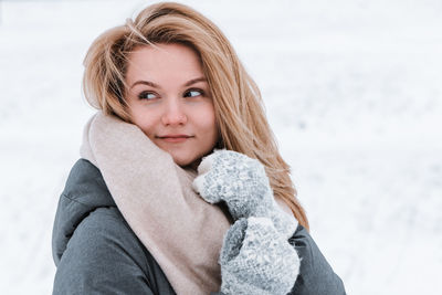 Portrait of young woman standing against sky