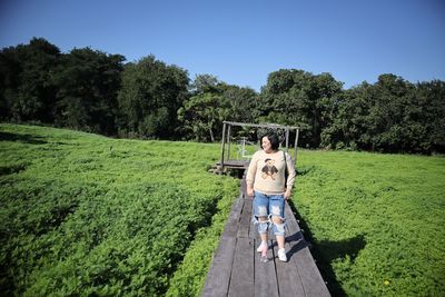 Man on field by trees against sky