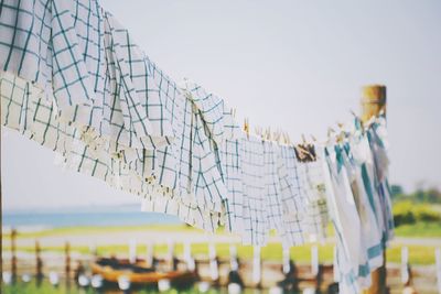 Low angle view of clothes drying on beach against clear sky