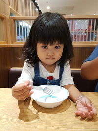 Portrait of happy girl holding table