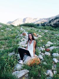 Portrait of young woman sitting on mountain