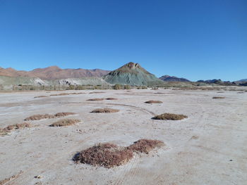 Scenic view of desert against clear blue sky