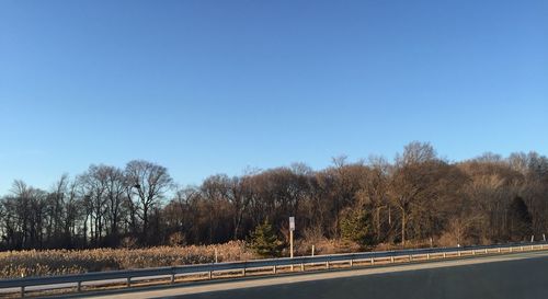 Empty road against clear blue sky