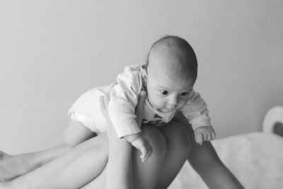 Midsection of woman playing with baby boy at home