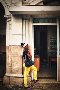 Full length of woman standing against building