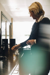 Senior businesswoman making tea at office canteen