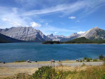 Scenic view of lake and mountains against blue sky