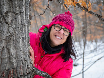 Portrait of smiling woman in snow covered tree