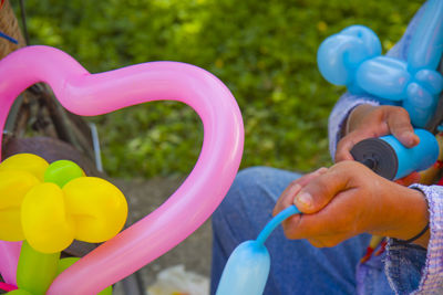 Close-up of hand holding colorful balloons