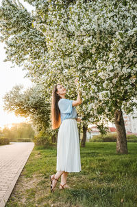 Rear view of woman standing on grassy field