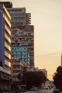 Buildings in city against sky during sunset