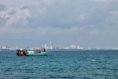 Boat sailing in sea against sky