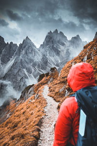 Rear view of man standing on mountain during winter