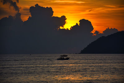 Silhouette sailboat in sea against sky during sunset