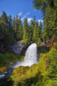 Scenic view of waterfall against sky