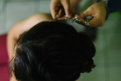 Cropped hands of hairdresser holding hair clip by bride