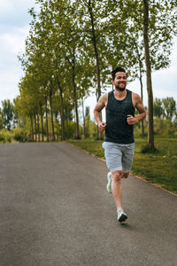 Portrait of young man running on road