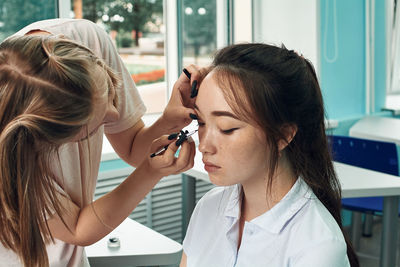 High school girls apply makeup. anime style