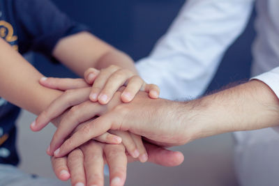Cropped image of family stacking hands