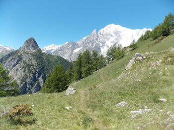 Scenic view of mountains against clear blue sky