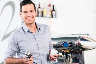 Portrait of smiling man holding camera