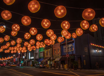 Street lights hanging on road by buildings at night