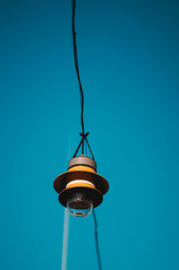 Low angle view of electric lamp against blue sky