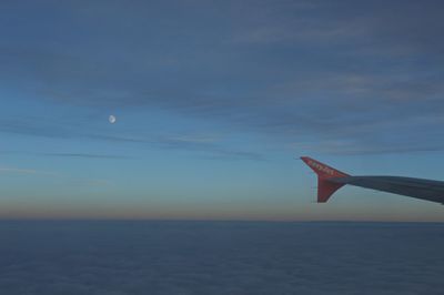 Airplane flying over sea against sky