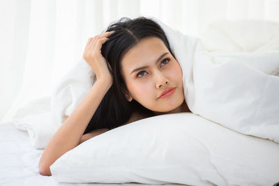 Portrait of woman lying on bed