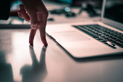 Close-up of businesswoman hand by laptop in office
