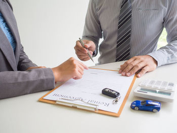 Midsection of man using laptop on table