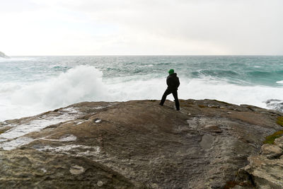 Full length of man standing at sea shore against sky