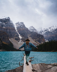 Rear view of man on lake against mountain