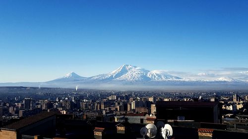 View of cityscape against clear blue sky