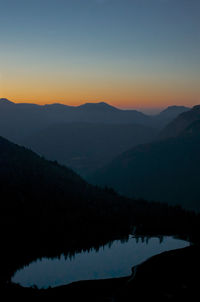 Scenic view of silhouette mountains against clear sky during sunset