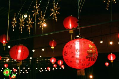 Low angle view of illuminated lanterns hanging at night